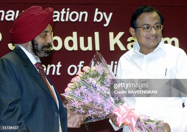 Indian Finance Minister P.Chidambaram receives a bouquet of flowers from Chairman and Managing Director of the Punjab National Bank, S.S. Kohli...