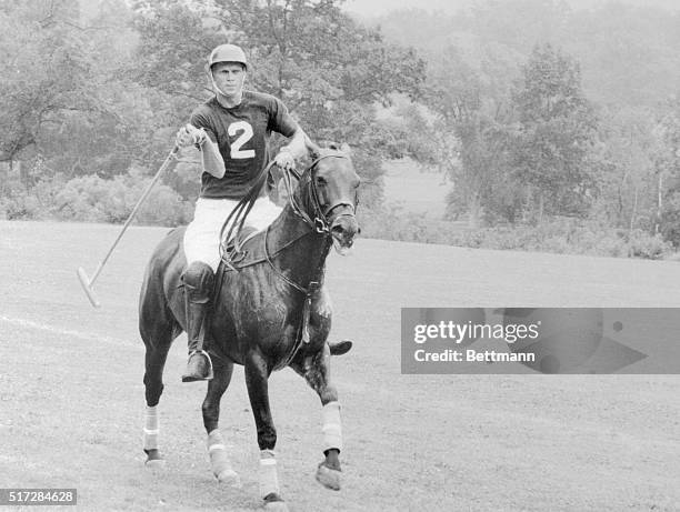 Mallet in hand, Steve McQueen zeroes in on the ball for a winning play during a country club polo match in United Artists' The Thomas Crown Affair.