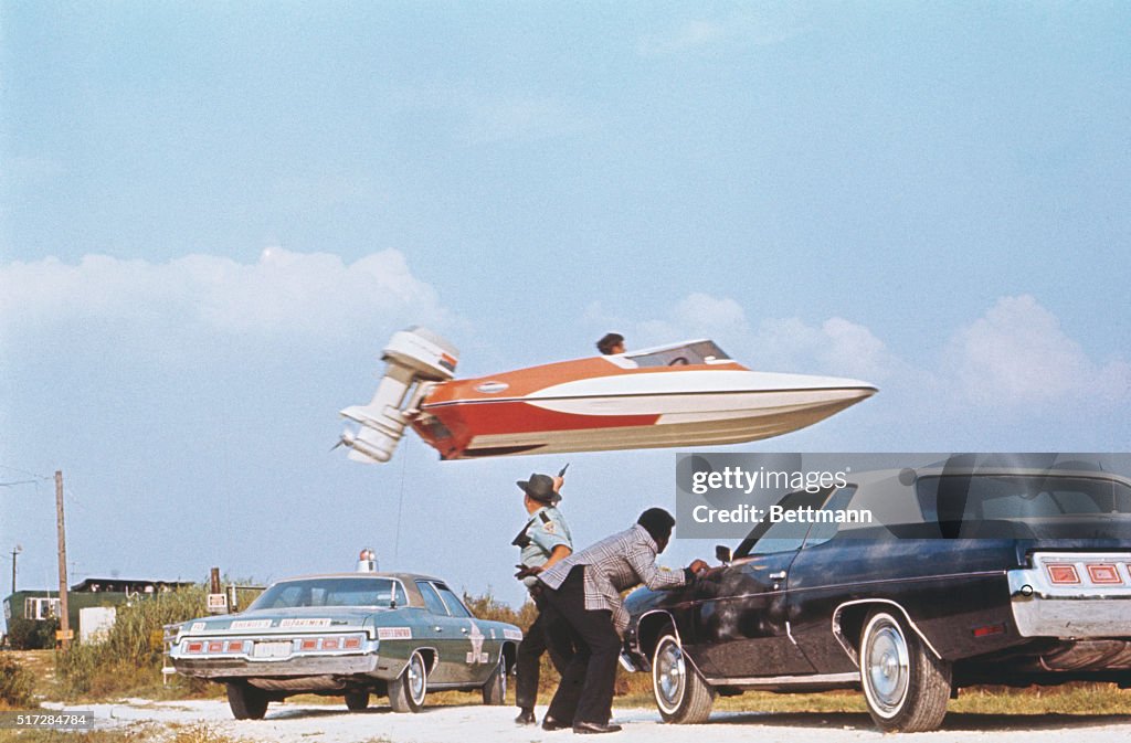 Stuntman Jumping a Speedboat over Cars