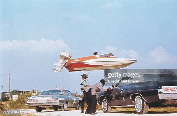 Stunt performer Jerry Comeaux jumps a Glaston GT-50 speedboat over police officers and their squads as part of an escape scene from the James Bond...