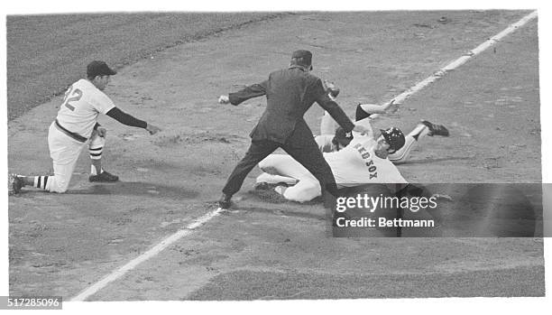 Boston: Aurelio Rodriguez, Tigers' 3rd baseman, is almost hidden by Carl Yastrzemski of the Red Sox who slides safely into 3rd base during 2nd inning...