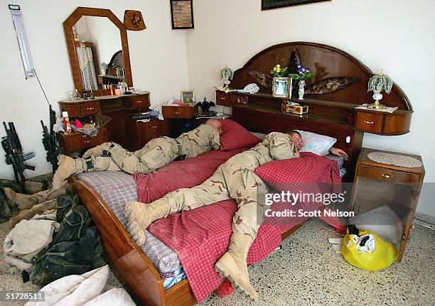 Army soldiers from the 1st Infantry Division's 2nd Battalion-2nd Regiment sleep in a captured Iraqi home November 10, 2004 during a break in fighting...