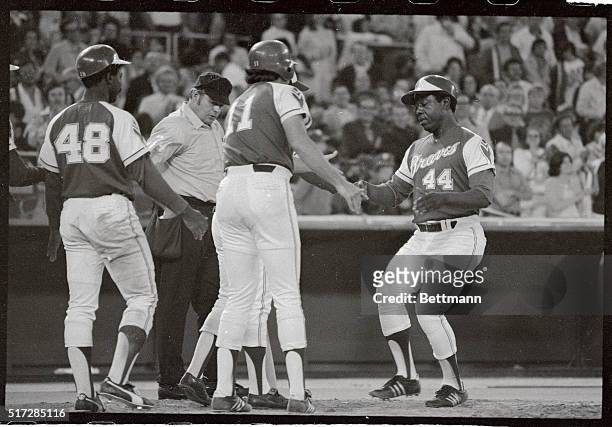 "Hammerin" Hank Aaron is congratulated by Braves teammate Darrell Evans , as he crosses the plate with a grand slam home run in the seventh inning...