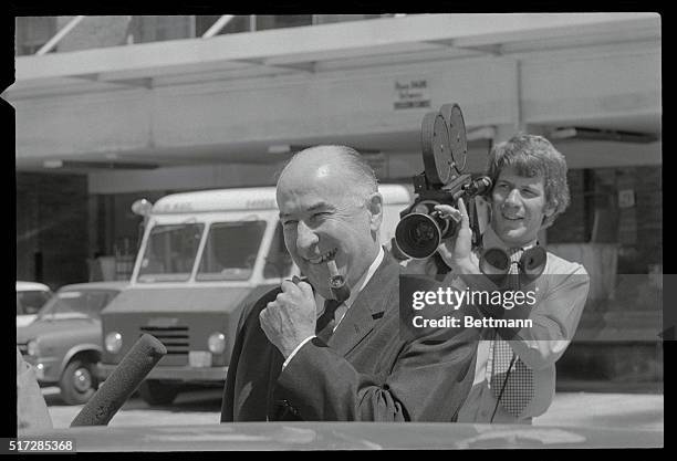 Miami, Florida: Former attorney general John Mitchell has a smile after photographers found him leaving the federal courthouse here by the back door....