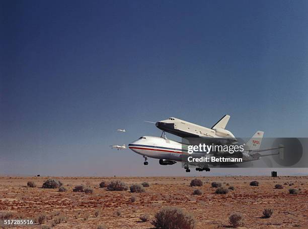 Edwards AFB, California: the space shuttle orbiter Enterprise, riding piggy back on its 747 mother ship, takes off from this test facility 6/18 on...