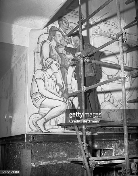 Diego Rivera, famous Mexican Artist, seen at work on the mural decorations of frescoes, he is painting in the Great Hall of the 70-story RCA Building...