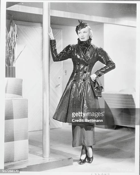 Hat-straw for cocktail coat--that is the unusual fabric selected for one of the ensembles worn by Ginger Rogers, RKO Radio Player. The black,...