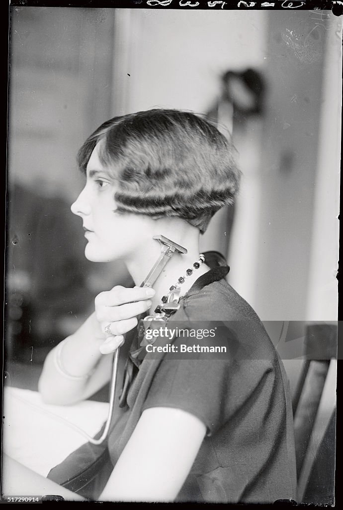 First Women Razor Miss Ethel Hale is shown here using the new electric safety razor ...