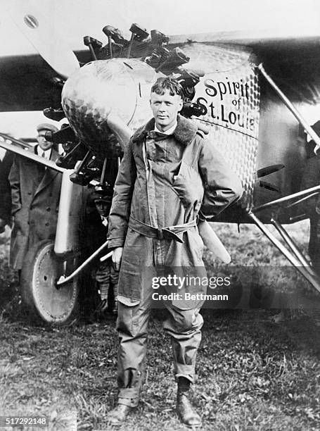 Charles Lindbergh standing in front of the Spirit of St. Louis.