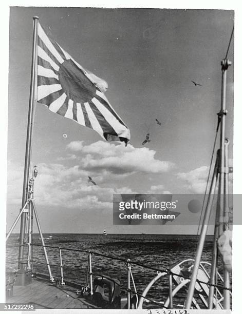 Flag of the rising sun of the Imperial Japanese Navy waving high over the Japanese man-of-war, Hiye 000 tons, during a cruise.