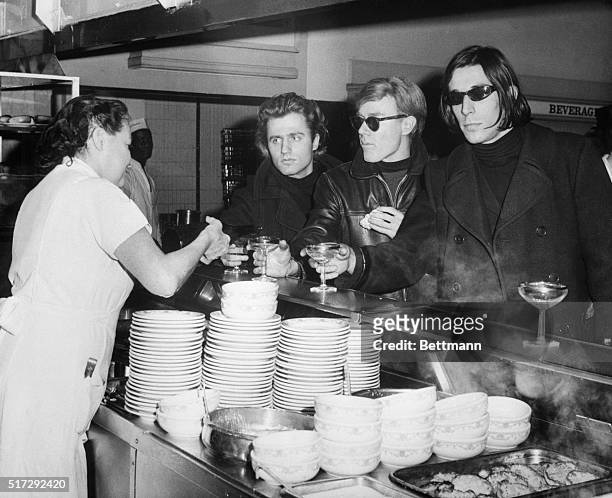 Left to right, Poet Gerard Malanga; artist-movie-maker Andy Warhol and avant-garde musician John Cale at the champagne breakfast held at the Automat...