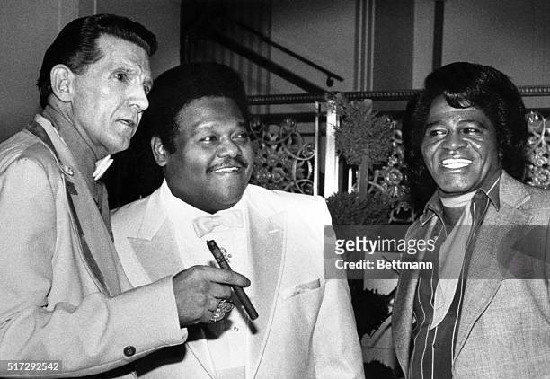 Jerry Lee Lewis, Fats Domino, and James Brown stand together at the Waldorf-Astoria Hotel. They were three of the first inductees into the Rock and...