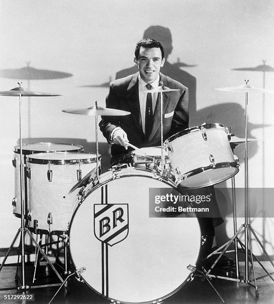 Buddy Rich seated at drum kit.