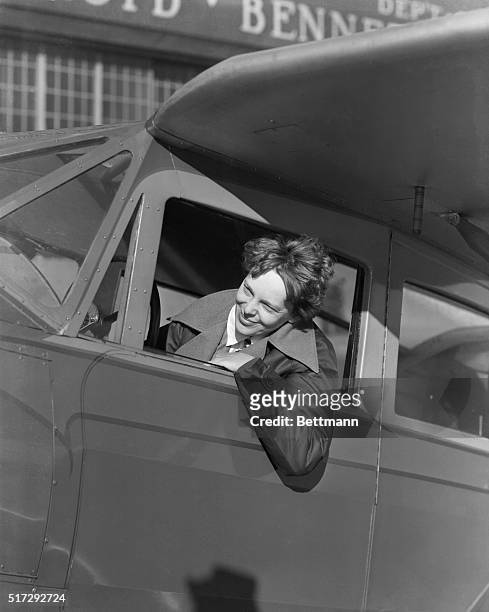 Amelia Earhart American aviatrix, first woman to cross the Atlantic ocean in an airplane. She is shown in plane cockpit. Photographic portrait.