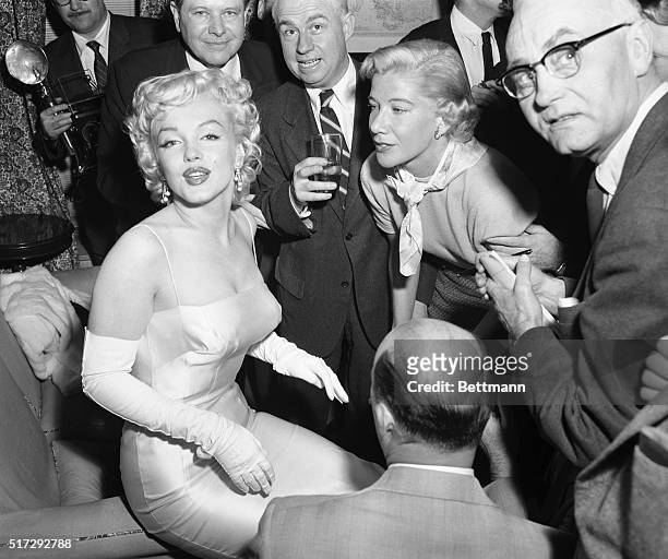 Actress Marilyn Monroe is surrounded by photographers and journalists as she is interviewed by Phyllis Battelle , who writes in the International...
