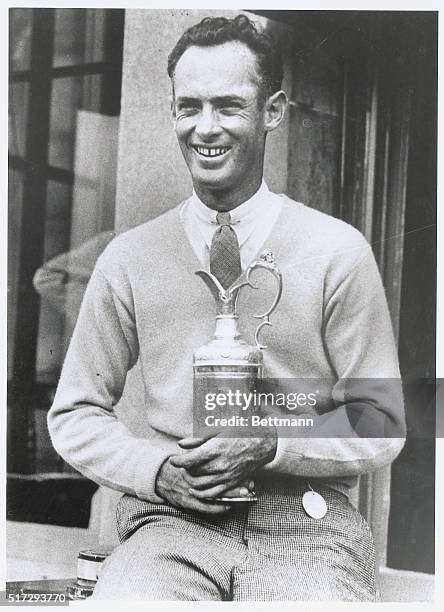 The Smile of Victory. Denny Shute, youthful American golf professional, with the championship cup after he had won the British Open Gold Championship...