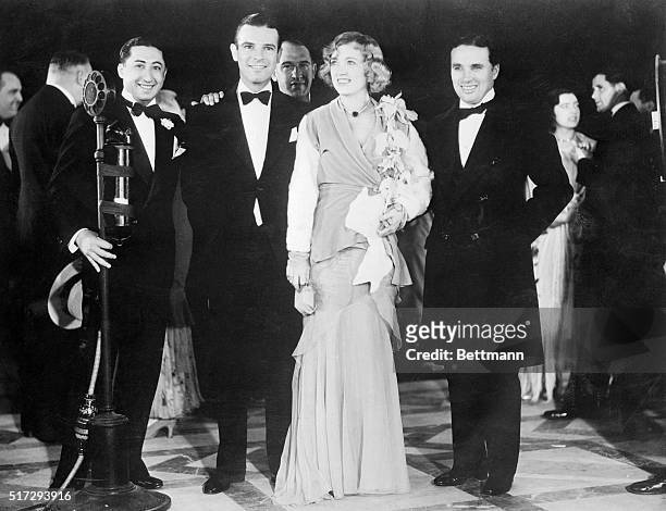 Attending Marion Davies, as she arrives for the premier of her new screen offering at a theatre in Hollywood, California, are some of the kings of...