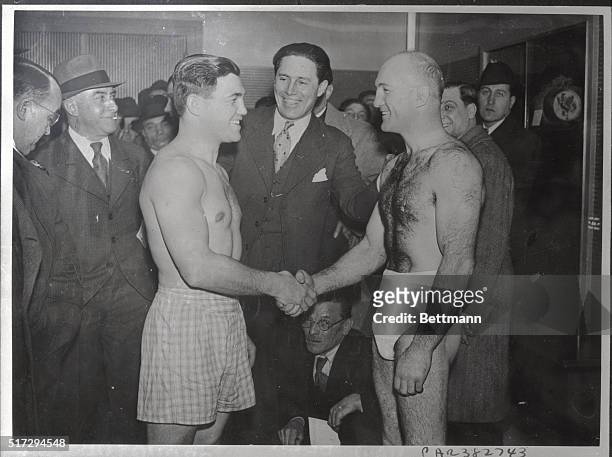 Lou Brouillard , American challenger, and Marcel Thil, French holder of the middleweight crown, shaking hands at the weighing-in ceremonies before...