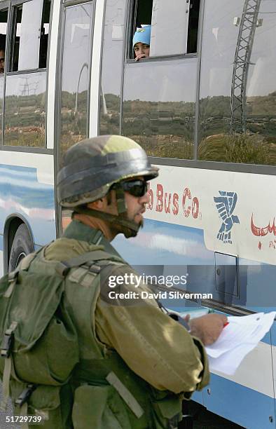 Palestinian girl looks out of a bus window as an Israeli soldier checks Palestinians on the bus at Tapuah Junction army checkpoin on November 11,...