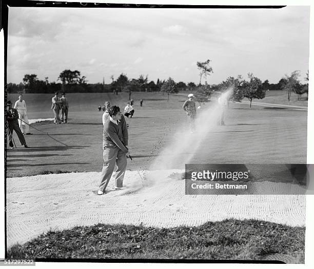 Lawson Little, shooting out of a sand trap, during a practice round for the Western Open Golf Championship at the Canterbury Country Club near...