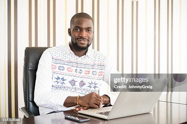 african businessman using laptop in modern office - nigeria man stock pictures, royalty-free photos & images