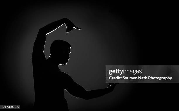 silhouette of a male indian dancer - asian male dancer stock-fotos und bilder