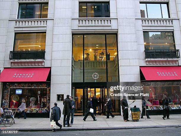 Pedestrians pass Barneys New York November 11, 2004 in New York City. The Jones Apparel Group has announced a deal to buy Barneys, the clothing chain...