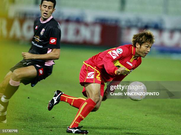 Japanese foward Atsushi Yanagisawa of Messina vies Palermo's Paolo Cotroneo during their Italian Serie A football match in Messina 11 November 2004....