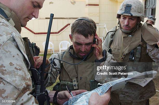 With hands bloodied from casualties on a convoy, U.S. Marine First Lt. Paul Webber calls coordinates for an air strike against insurgents on November...