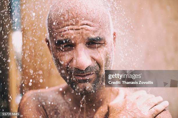 portrait of a man under a shower - hombre en la ducha fotografías e imágenes de stock