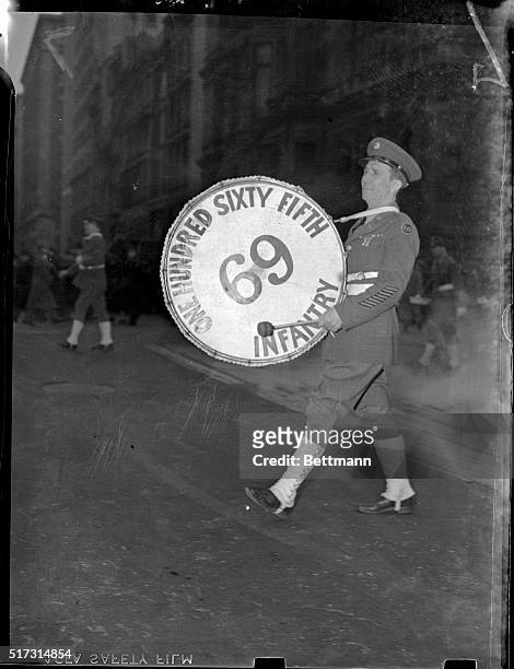 New York, NY: Bass drummer for the One Hundred and Sixty-Fifth Infantry band is shown walking with his bass drum strapped on. Ca. 1930s.