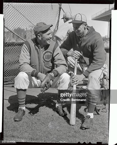 Dizzy Dean, the former St. Louis cardinals pitcher who now performs for the Chicago Cubs, talks it over with Lon Warneke, one time star pitcher of...