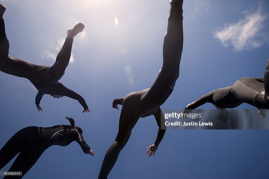 Sky Silhouette, 4 people in wetsuits jumping