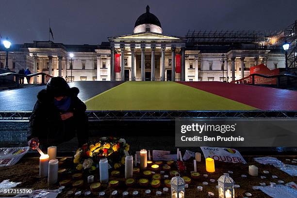 Mourner lights a candle in Trafalgar Square during a candlelit vigil in support of the victims of the recent terror attacks in Brussels on March 24,...