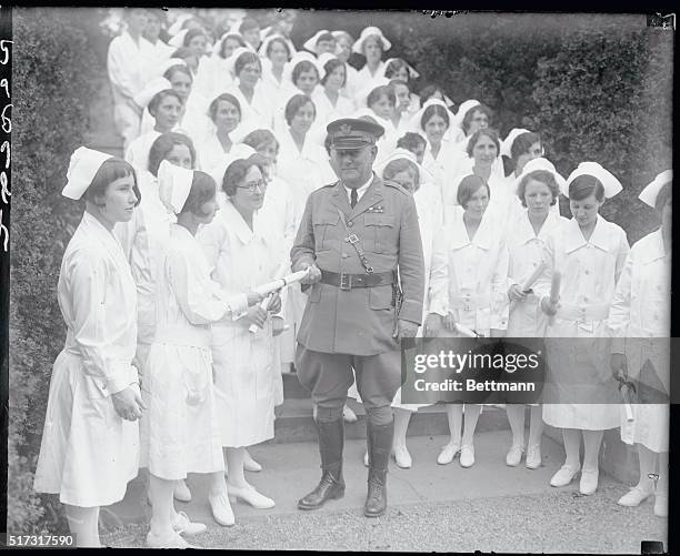 General James M. Kennedy gives a diploma to Elva McCalmon during the graduation of 42 student nurses at Walter Reed Hospital.