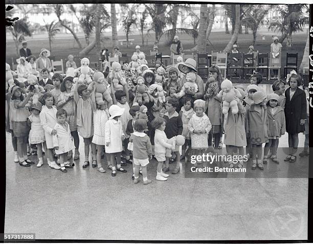 Rose O'Neill, creator of the Kewpie Doll, shown with children and dolls.