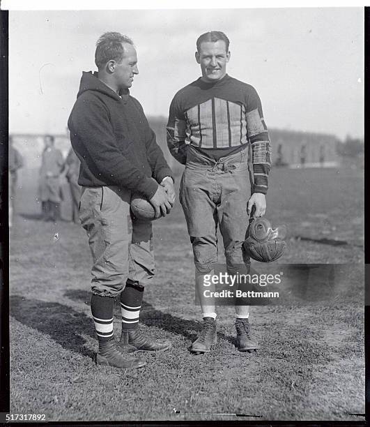 Harold "Red" Grange, famous collegiate and professional football player, with Heinie Miller, coach of the Temple University football team, just...