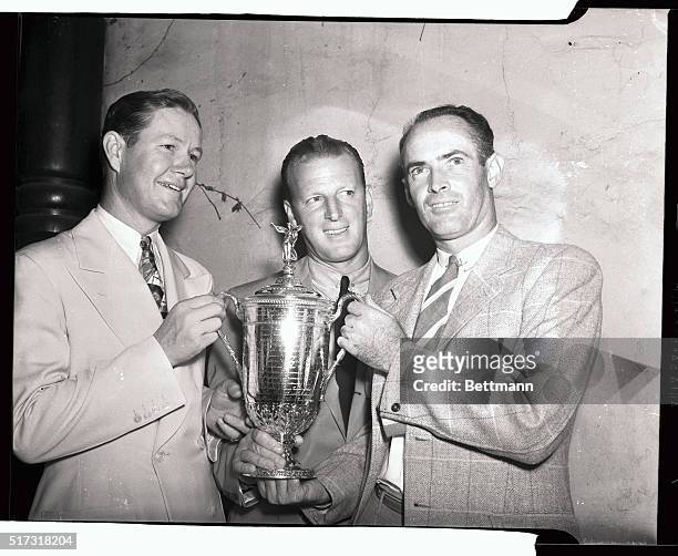 Byron Nelson, Craig Wood, and Denny Shute , as each man has a hand on the trophy, after they shot themselves into a three-way tie for the National...