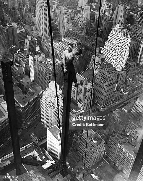 New York City: Carl Russell waves to his co-workers on the structural work of the 88th floor of the new Empire State Building. When complete the...
