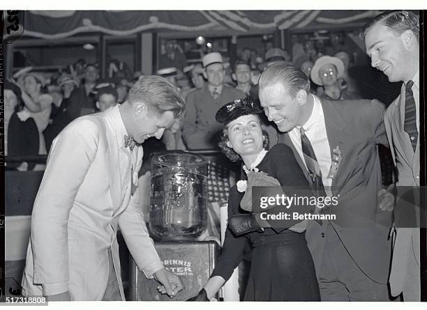 Joseph P. Kennedy Jr., son of the Ambassador to England; Elliot Roosevelt, , son of the President, and Mrs. Elliot Roosevelt, are shown around a...