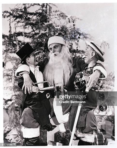 Hollywood, CA- Charlie McCarthy and his timber contemporary, Mortimer Snerd, strike a "Night Before Christmas" pose with Edgar Bergen, the man who...
