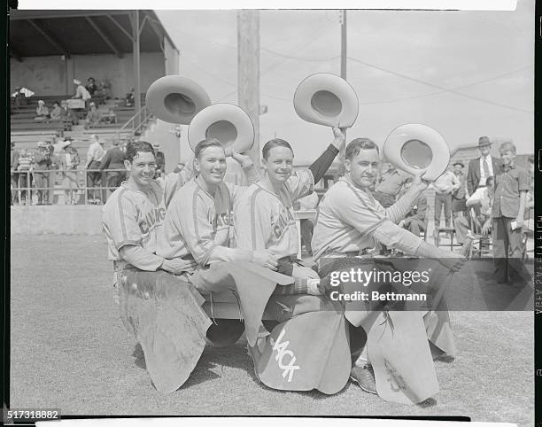 Using a players' bench and a bat for a horse, three members of the Chicago Cubs, in Tucson, Arizona, for an exhibition game, played cowboy with an...