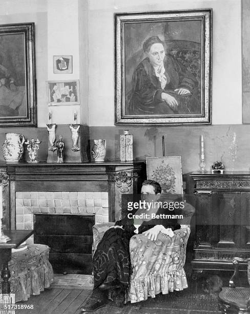 Paris, France: Writer Gertrude Stein seated before a portrait of herself that was painted by Picasso.