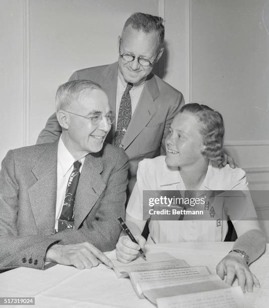 National women's golf champion Patty Berg signing a contract with the Wilson Sporting Goods Co., Chicago, to become a golf professional. Watching the...