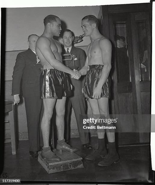 Champion Henry Armstrong and Fritzie Zivic weighing in for their 15-round welterweight title bout at Madison Square Garden. Armstrong at 145 1/2 held...