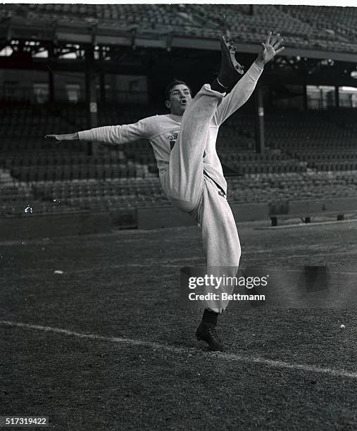 Sammy Baugh, star passing back of the Washington Redskins, Eastern Division pro football champions, loosens up his kicking leg as the Washington team...