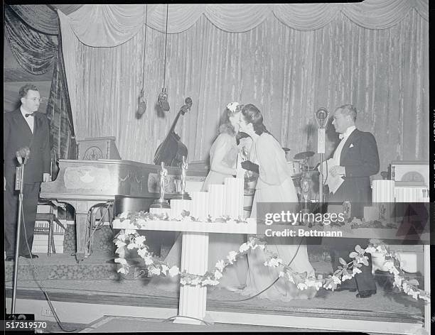 The 13th Annual Awards Dinner of the Academy of Motion Picture Arts and Sciences at the Biltmore Hotel. Actress Ginger Rogers receiving a kiss and...