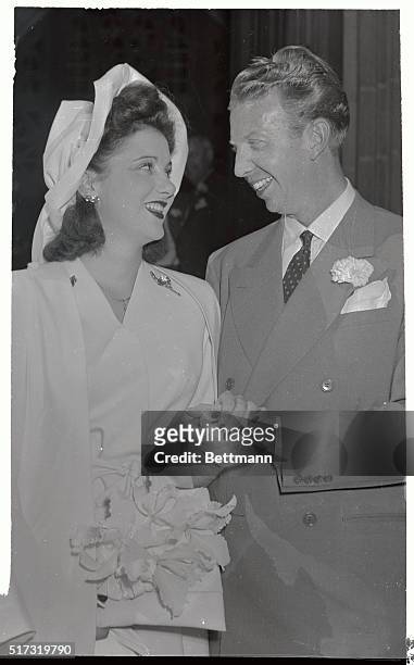 Don Budge, number one pro tennis star, radiates happiness as he holds the hand of his bride, the former Deirdre Conselman, of Glendale, California,...