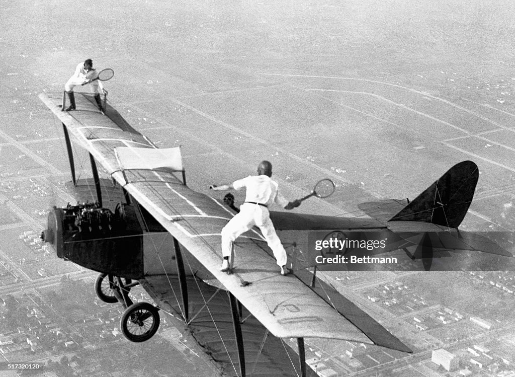 Daredevils Playing Tennis on a Biplane