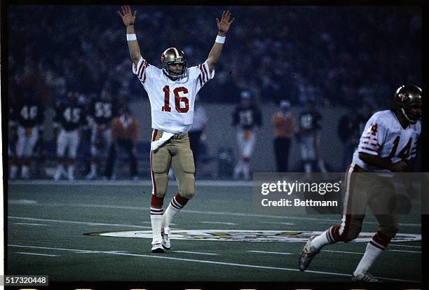 Joe Montana, San Francisco 49ers' quarterback, is shown with his arms raised in victory.